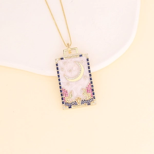 Detail of 18K gold tarot moon pendant featuring zircon inlay and celestial motifs
