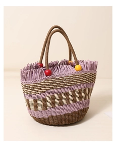 Detailed view of woven straw bucket bag with purple fringe and colorful wooden beads