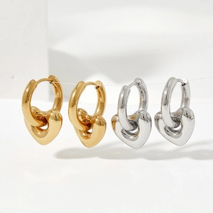 Polished stainless steel heart drop earrings in gold and silver finish on display