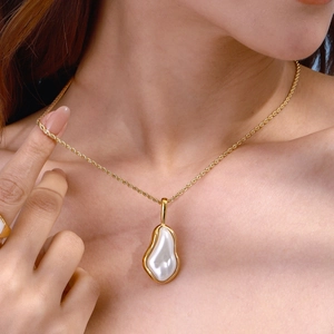 Elegant gold twist chain necklace with a unique baroque pearl pendant on model skin