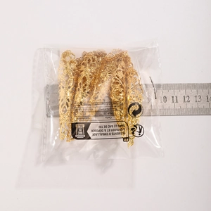 Dettaglio di armature per dita punk dorate in confezione con righello per la dimensione