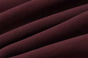 Detailed macro view showing the texture and drape of dark burgundy lace dress fabric