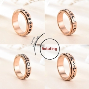 Rose gold spinner rings detail featuring sun, moon, star patterns and rotating band mechanism