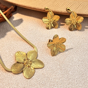 Golden stainless steel jewelry set featuring petal pendant necklace and stud earrings