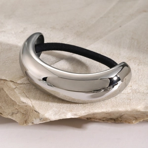 Polished stainless steel hair ring with elastic band on natural stone background