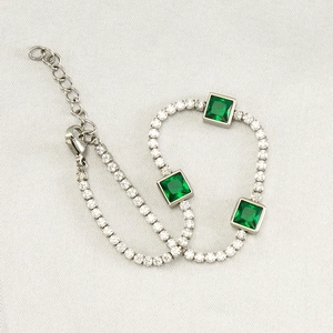 Detailed view of silver-tone bracelet with emerald-green stones and cubic zirconia