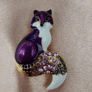 Détail de la broche renard en émail violet ornée de strass brillants sur métal doré