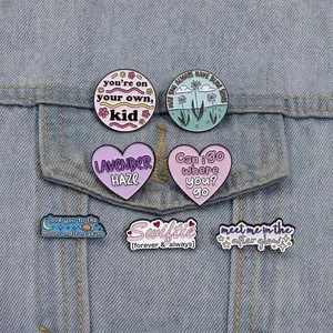 Set of Taylor Swift inspired enamel pins displayed on a denim jacket pocket