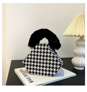 Detail of houndstooth handbag featuring a plush black faux fur handle and geometric shape