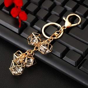 Detailed view of geometric gold crystal keychain featuring faceted gems on a black keyboard