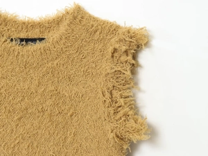 Detailopname van de mosterdgele imitatiebonttextuur en de ronde halslijn van het vest