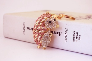 Detailed close-up of pink crystal hedgehog keychain with gold plating and rhinestones