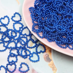 Blue heart-shaped ABS pearl beads for DIY nail art and craft decoration in a pink dish
