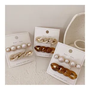 Detail of elegant pearl hair clips and tortoiseshell chain barrettes on card sets