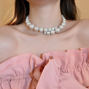 Close-up of double-layer necklace featuring assorted pearls and silver beads on neck