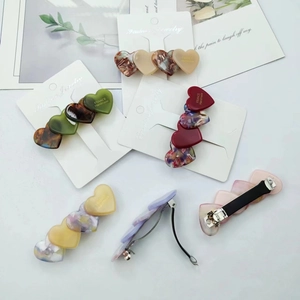 Close-up of marble pattern acetate heart hair clips with metal spring mechanism