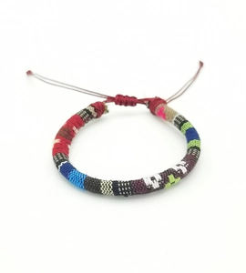 Detail of colorful hand-woven bohemian bracelet with adjustable red cord tie