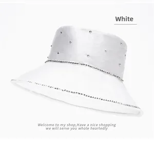 Detail of white satin bucket hat with sparkling pearl and rhinestone trim for beach sun protection