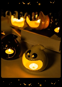 Close-up of a ceramic ghost candle holder with tea lights creating a spooky atmosphere