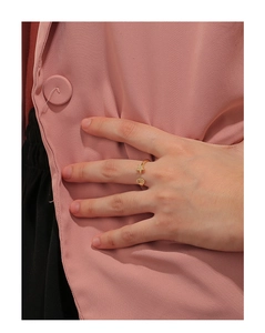Detail eines vergoldeten Rings mit Seestern, Muschel und Zirkonia an der Hand des Models