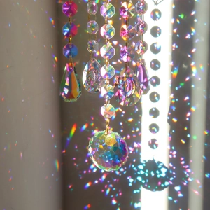 Detail of crystal suncatcher pendants casting vibrant rainbow light spots on wall