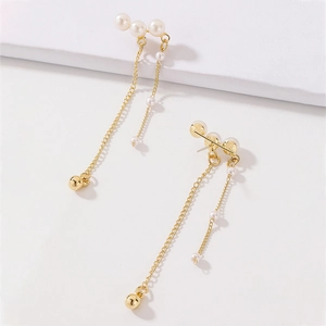 Detail view of gold tassel earrings with faux pearls and dangling metallic chains