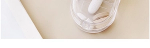 Close-up of a clear portable pill cutter box showing the internal dividing structure