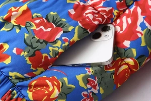 Detail of floral printed jacket pocket featuring blue background and red rose pattern
