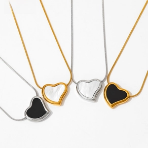 Macro view of gold and silver heart pendants on snake chains in black and white colors