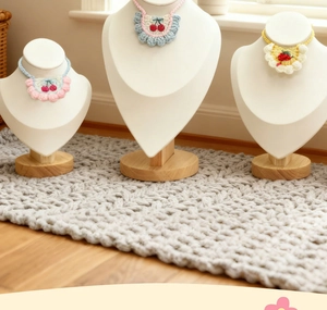 Detail of three handmade crochet pet collars featuring cherry and strawberry fruit designs