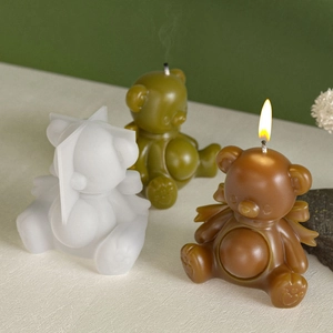 Detail of bear silicone mold with finished wax candles featuring wings and heart paws