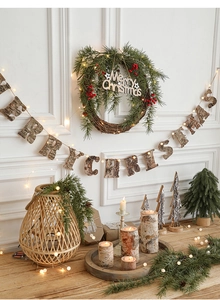 Detail of a Merry Christmas wooden banner with pine wreath and warm LED lighting decorations