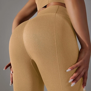 Close-up of high-waist yoga pants featuring seamless honeycomb texture in mustard yellow