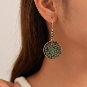 Detail view of vintage bohemian flower drop earrings worn by a model in natural light