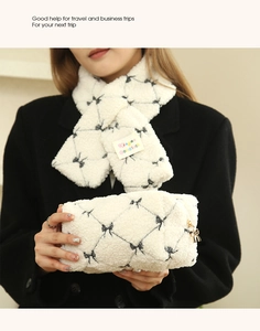 Detail of white plush cosmetic bag with bow zipper and matching fuzzy scarf set