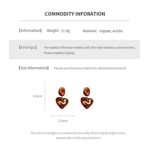 Detailed view of amber acrylic heart earrings with weight 11.9g and 4.3cm length
