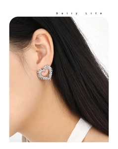 Close-up of heart-shaped earring with baguette zircons worn by an Asian model