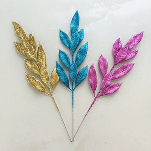 Glittering artificial Christmas branches in gold blue and purple for festive holiday decor