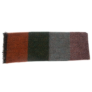 Macro detail of plaid scarf with orange, green, and brown woven blocks and soft fringe