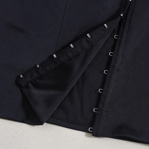 Detail of metal hook-and-eye closure on black camisole with precision stitching
