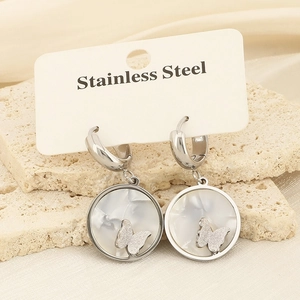 Macro detail of stainless steel butterfly earrings with shell inlay on a stone stand