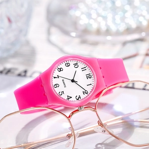 Detailed shot of pink silicone quartz watch placed on stylish glasses background