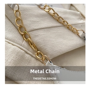 Detail of premium gold metal chain and white synthetic leather on luxury women bag