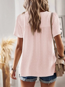 Detail view of pink short sleeve blouse featuring pleated back yoke and textured dot fabric