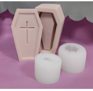 Detail of coffin-shaped silicone mold with cross relief and cylindrical candle molds