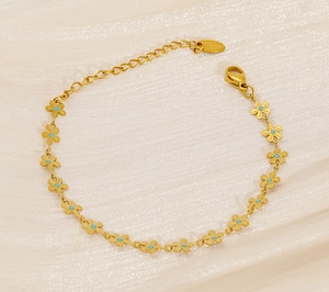 Detailed macro view of a gold-plated daisy bracelet on premium silk textured background