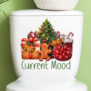 Detail showing Christmas tree and gingerbread man stickers on a white toilet tank surface