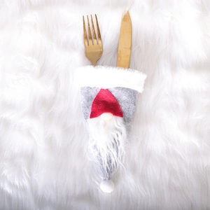 Christmas gnome cutlery holder with grey felt and red hat on white fur background