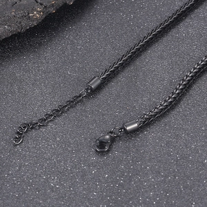 Detail einer schwarzen Titanstahlkette mit Karabinerverschluss und Verlängerungsgliedern
