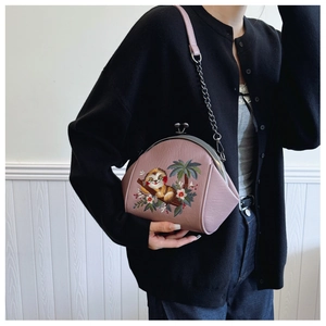 Close-up of pink shell bag featuring sloth floral embroidery and silver chain strap